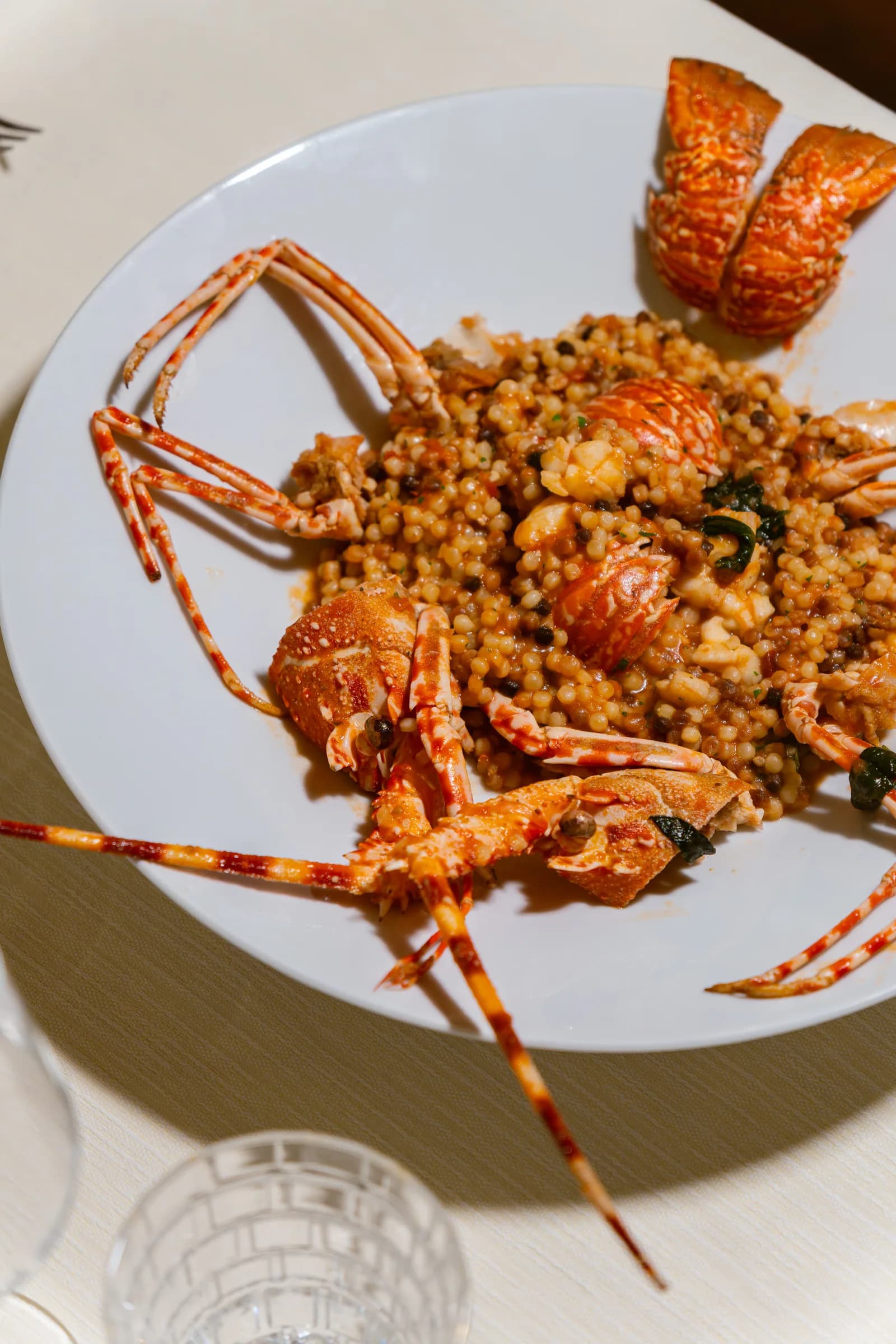 Fregola con crostacei servita nel piatto, piatto di mare di Ottone
